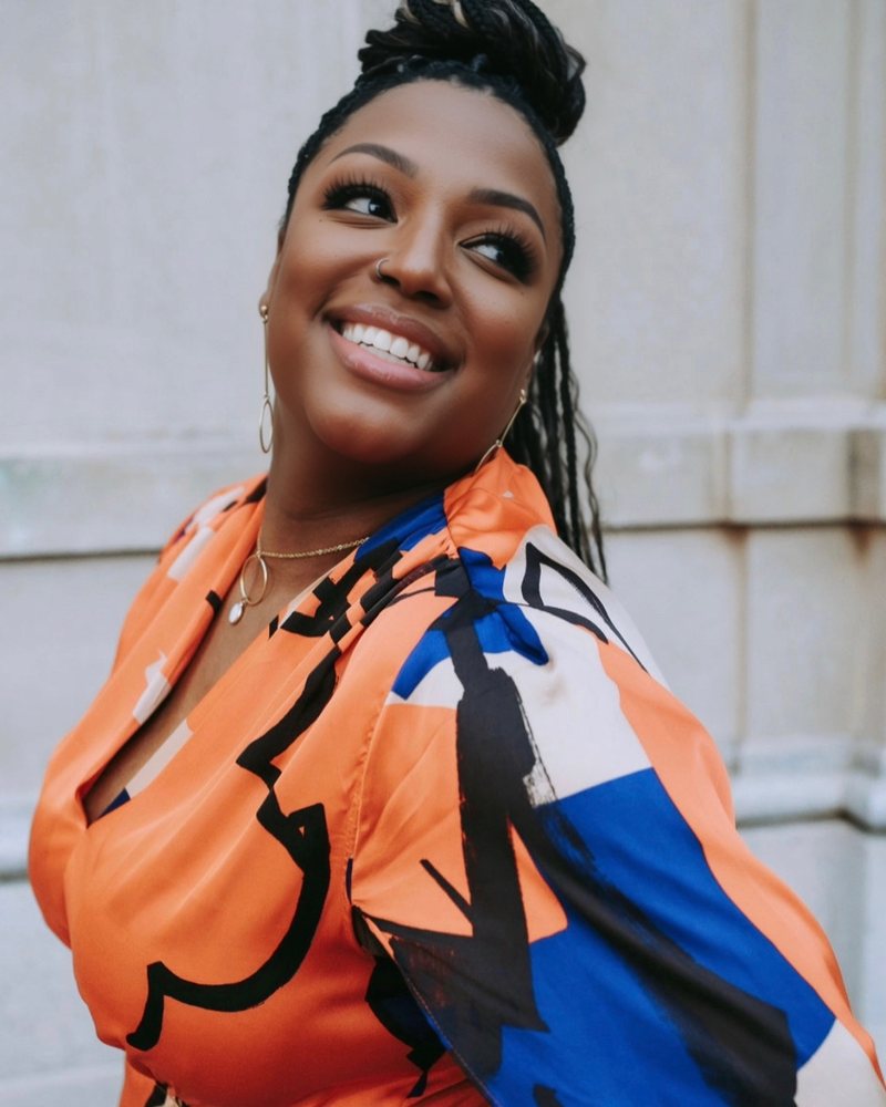 Jessica D. Maine-Jackson smiling, wearing an orange and blue print top